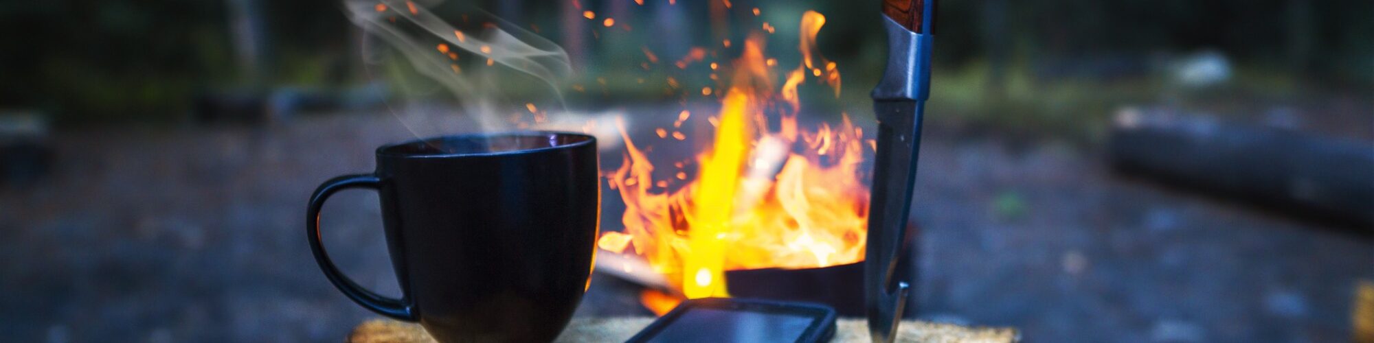 Camping in freier Natur mit einem heißen Getränk und Lagerfeuer Camping in freier Natur mit einem heißen Getränk und Lagerfeuer